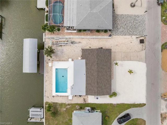 Aerial view of property's location featuring extended coastline and beach just steps away