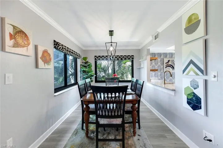 Dining area featuring hardwood / wood-style floors, sink, and crown molding