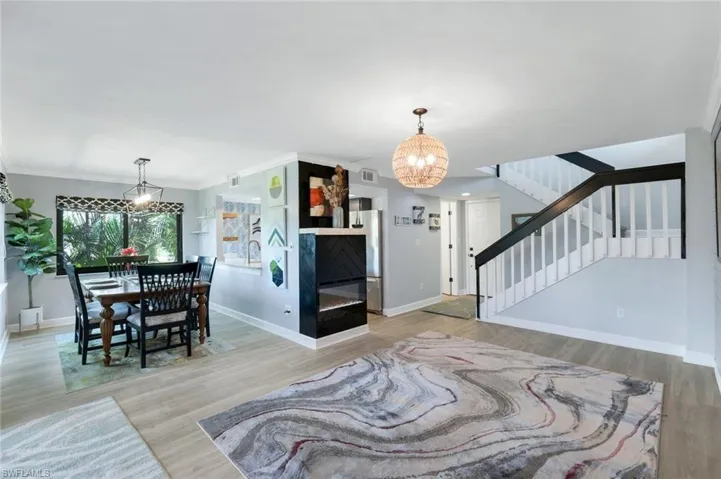 Living room with hardwood / wood-style flooring, a notable chandelier, and ornamental molding