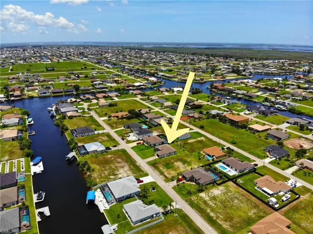Aerial view of property's location with a nearby body of water and nearby suburban area