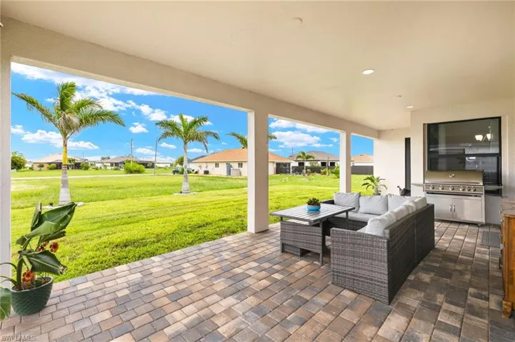 View of patio with an outdoor kitchen, an outdoor hangout area, and a residential view