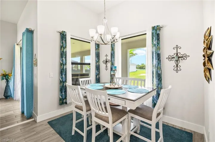 Dining area with plenty of natural light, a chandelier, and light wood-style floors