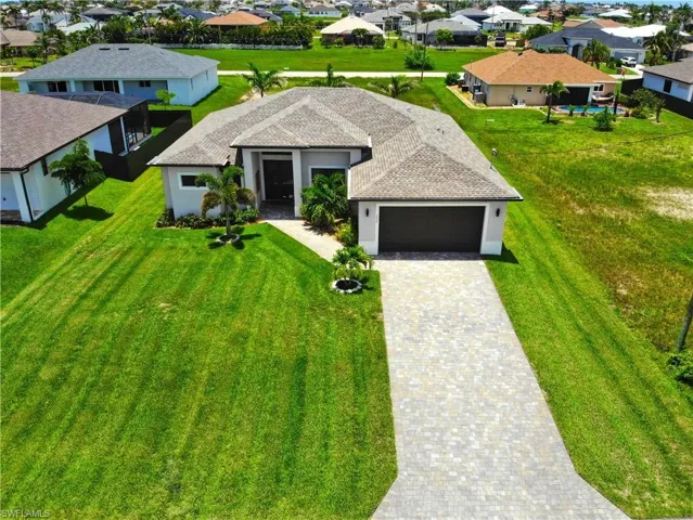 View of front of property with a garage, decorative driveway, stucco siding, and a residential view