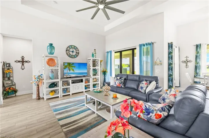 Living area featuring a high ceiling, a ceiling fan, recessed lighting, french doors, and light wood-type flooring