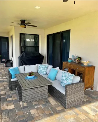 View of patio with an outdoor hangout area and ceiling fan