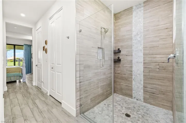 Ensuite bathroom with a stall shower, recessed lighting, and wood finished floors