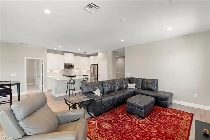 Living room with light wood finished floors and recessed lighting
