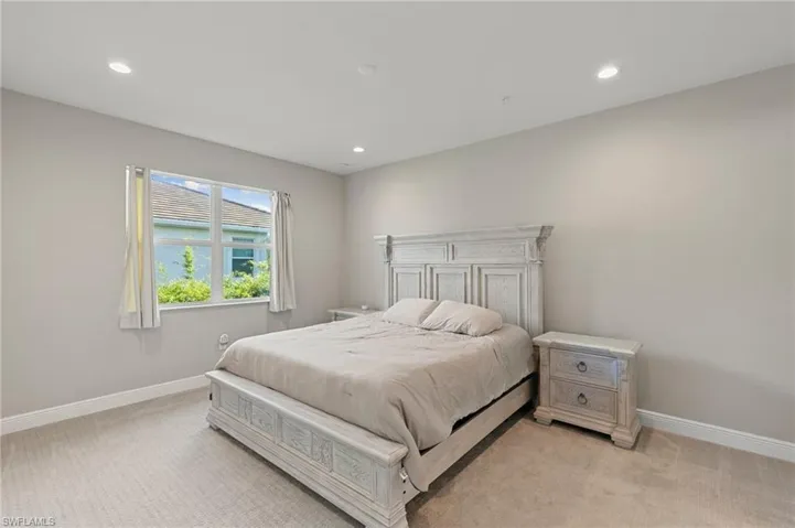 Bedroom with light colored carpet and recessed lighting