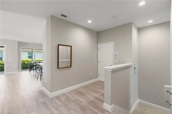 Corridor with light wood finished floors and recessed lighting