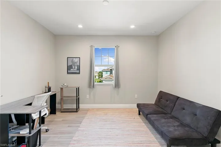 Home office with light wood-style flooring and recessed lighting