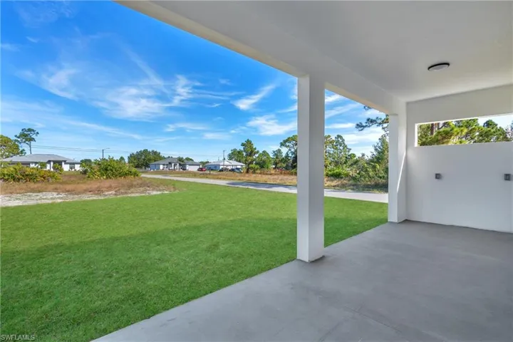 View of grassy yard with a patio area