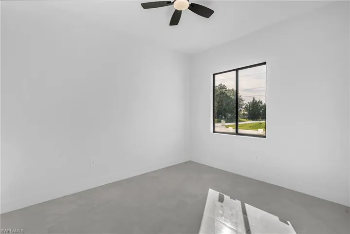 Unfurnished room with ceiling fan and concrete floors