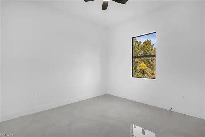 Empty room with a ceiling fan and concrete floors