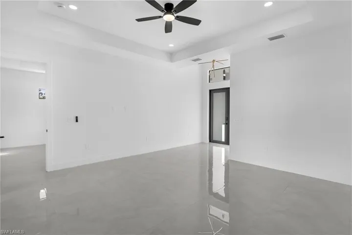 Spare room with recessed lighting, a ceiling fan, and a tray ceiling