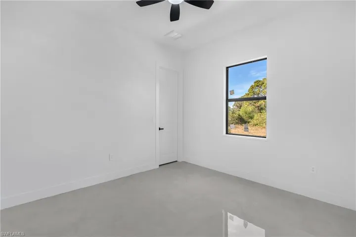 Empty room featuring ceiling fan and concrete flooring