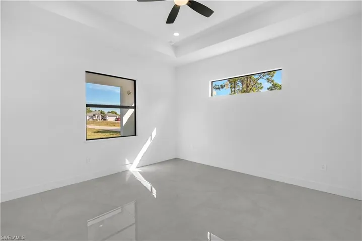 Spare room featuring a tray ceiling, a ceiling fan, and recessed lighting