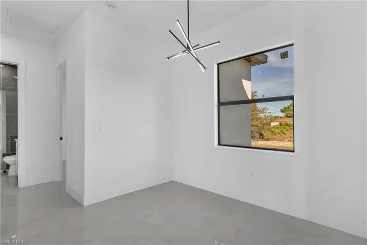 Unfurnished dining area featuring baseboards and a chandelier