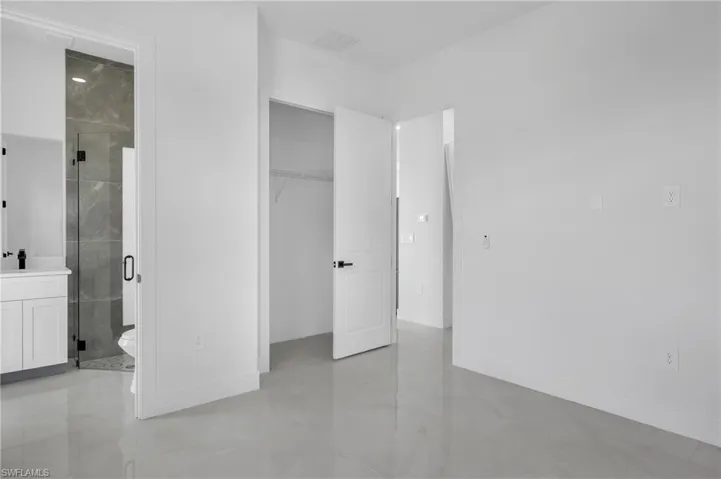 Unfurnished bedroom with baseboards and ensuite bath