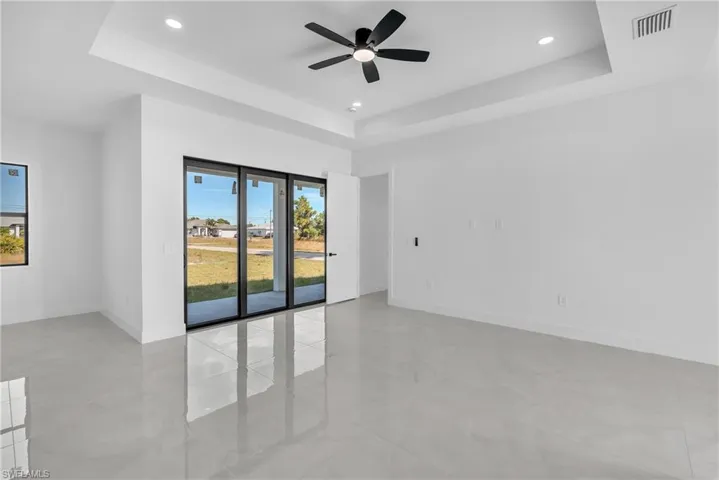 Spare room with a tray ceiling, ceiling fan, and recessed lighting