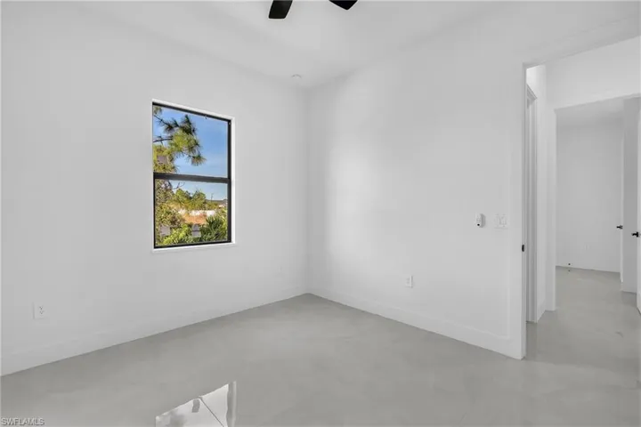 Empty room with a ceiling fan and concrete flooring