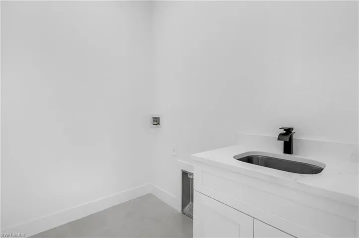 Laundry area featuring hookup for a washing machine and light tile patterned floors