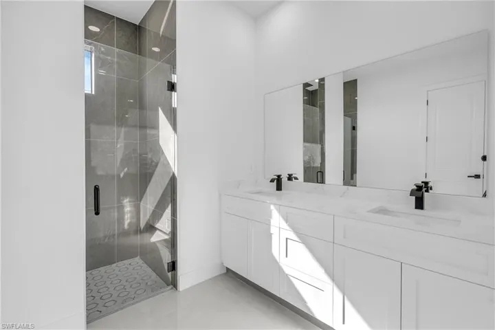 Bathroom with double vanity and a stall shower