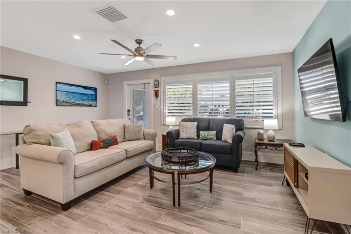 Living room with a ceiling fan, recessed lighting, and wood tiled floors