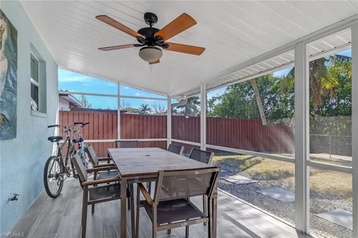 Sunroom / solarium with outdoor dining area and ceiling fan