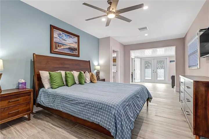 Bedroom featuring french doors, wood finish floors, access to exterior, a ceiling fan, and recessed lighting