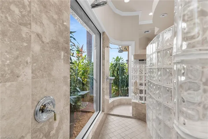 Master Bath Shower has 2 heads & lush tropical privacy garden plus electric storm shutter