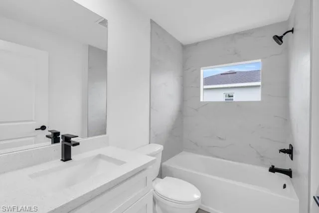 Bathroom featuring a white vanity with a quartz-finish countertop, integrated sink, and black matte faucet