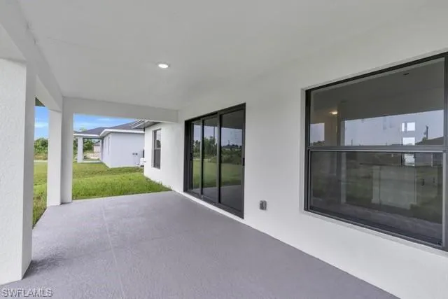 Covered patio featuring a smooth concrete floor, recessed lighting, and white columns