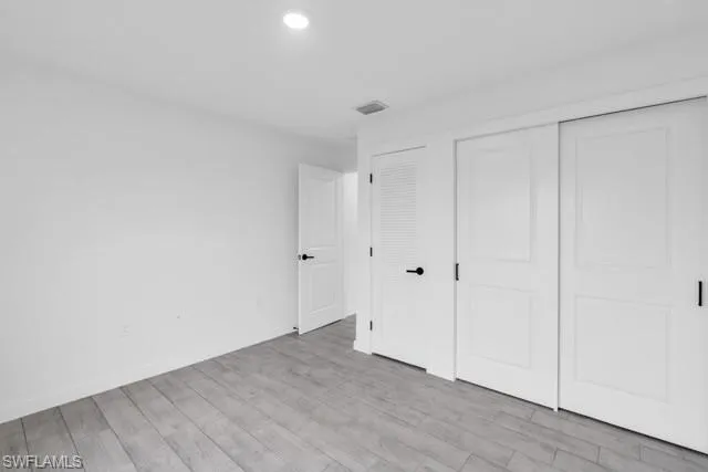 Light gray wood-finish flooring complements white walls and modern matte black hardware