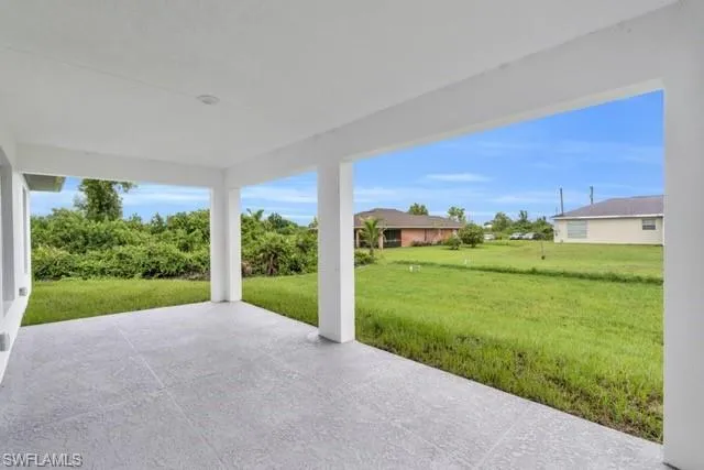 Covered patio featuring a textured concrete slab, white columns, and a recessed light fixture