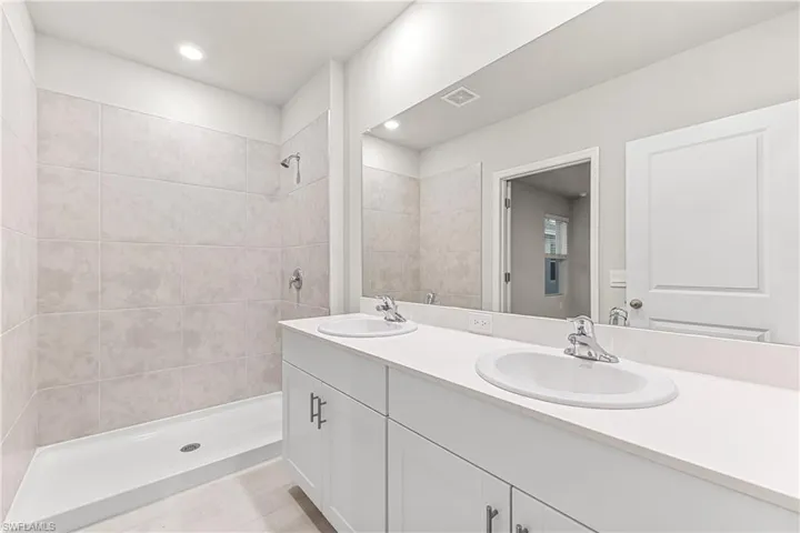 Bathroom with tiled shower and vanity