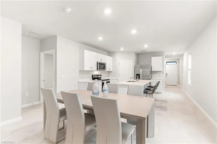 Dining space with light hardwood / wood-style flooring and sink