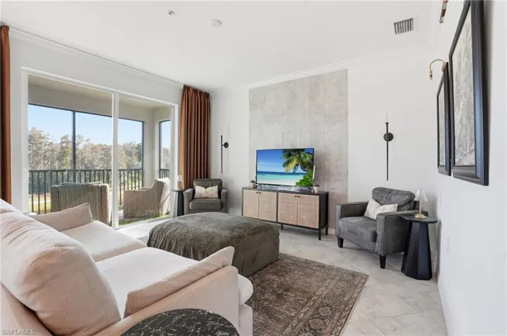 Living room featuring ornamental molding and light tile patterned floors