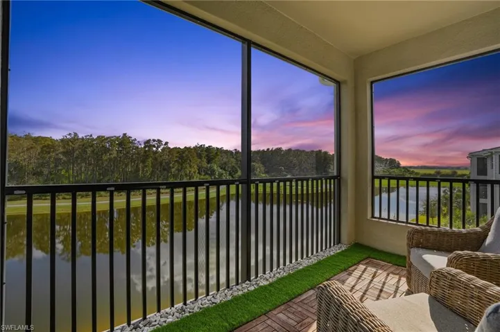 Lanai with a water view and view of scattered trees