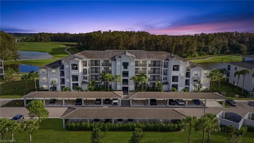 View of apartment building / complex with covered and uncovered parking, a water view, and golf course view