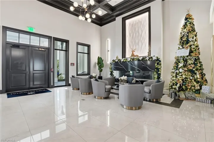 Clubhouse lobby with coffered ceiling, a high ceiling, beamed ceiling, and crown molding