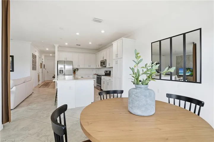 Dining area featuring crown molding, recessed lighting, and light tile patterned floors