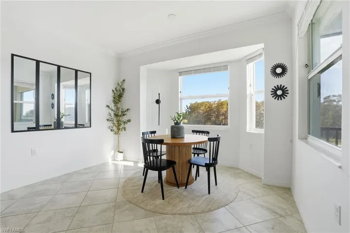 Dining area featuring ornamental molding, plenty of natural light, and light tile patterned floors