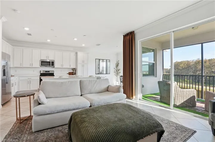 Living area featuring light tile patterned floors, recessed lighting, and ornamental molding