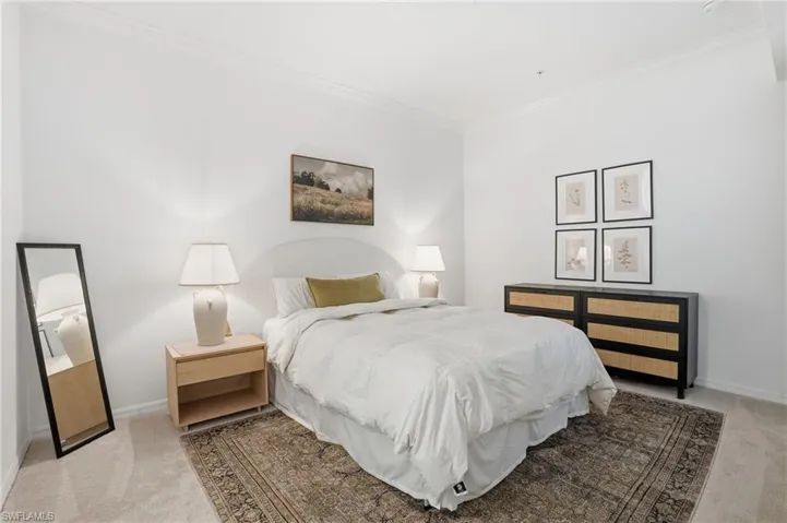 Bedroom with light colored carpet and crown molding