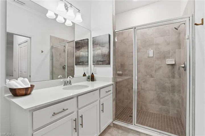 Bathroom featuring a shower stall and vanity