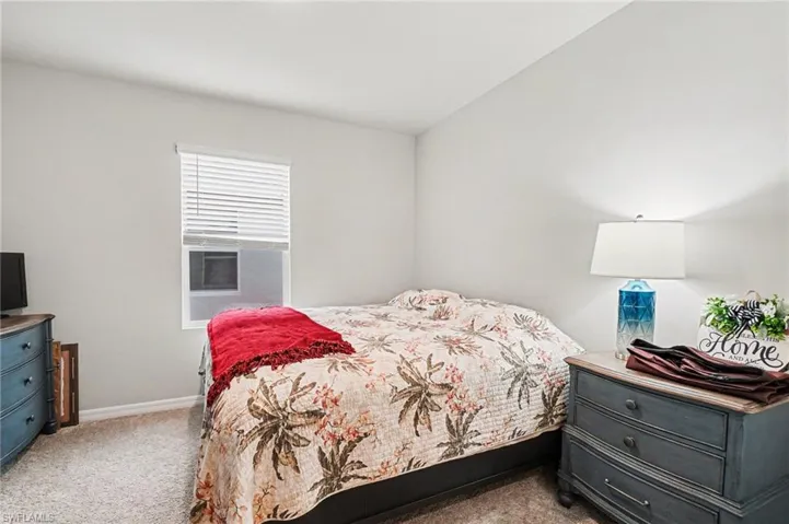 Bedroom featuring light carpet and baseboards