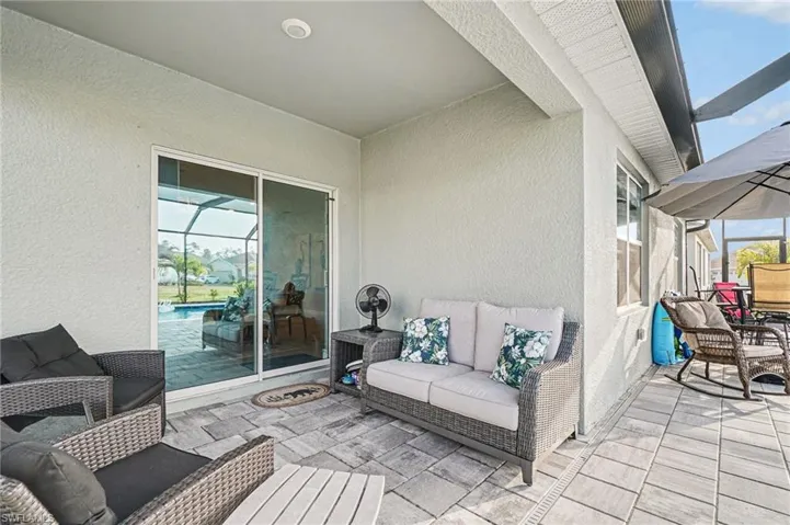 View of patio with a sunroom, glass enclosure, and an outdoor hangout area