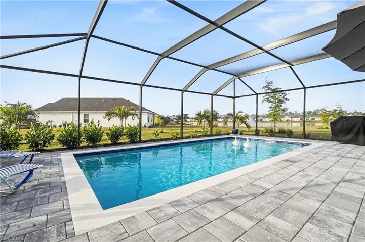 Outdoor pool featuring a sunroom, a grill, a lanai, and a patio