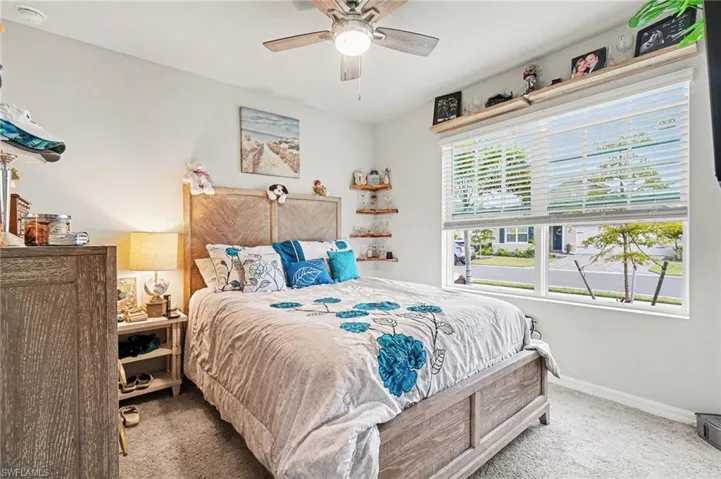 Carpeted bedroom featuring ceiling fan and baseboards