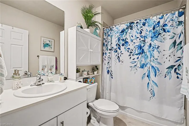 Full bath featuring vanity and shower / bath combination with curtain